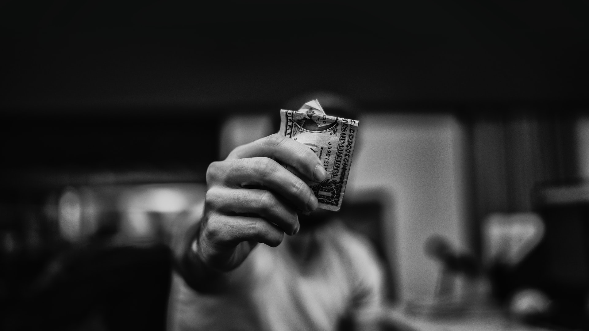 man holding 1 US dollar banknote